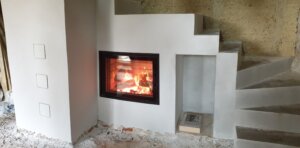 Poêle de masse escalier Ortner  - réserve de bois - enduit blanc